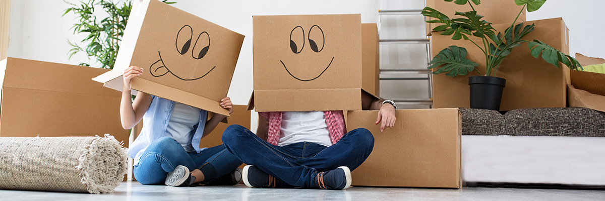 Couple with hand drawn faces on moving boxes