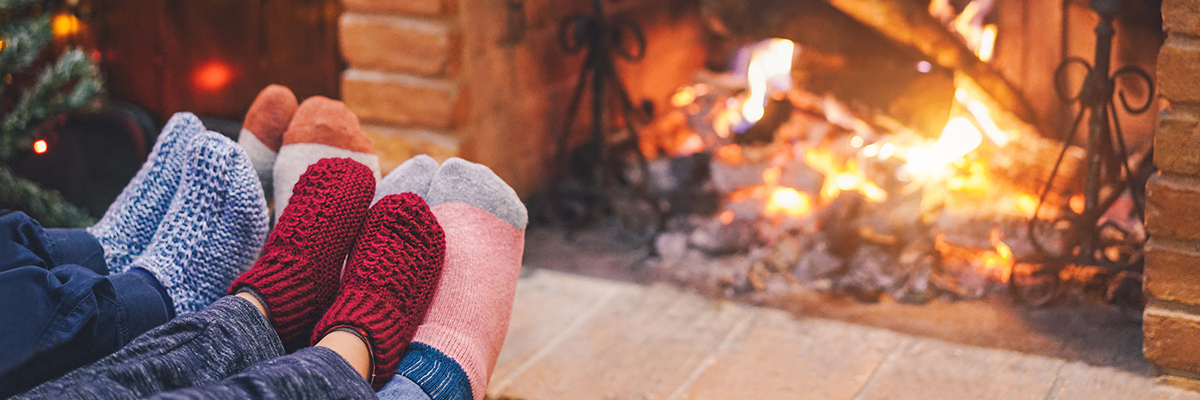 Feet with socks warming by the fireplace