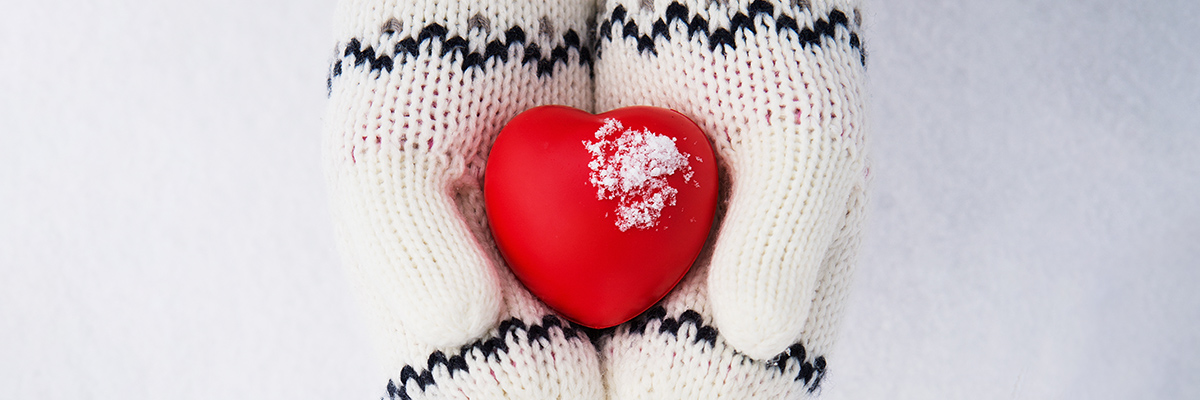 Gloved hands in winter holding a heart