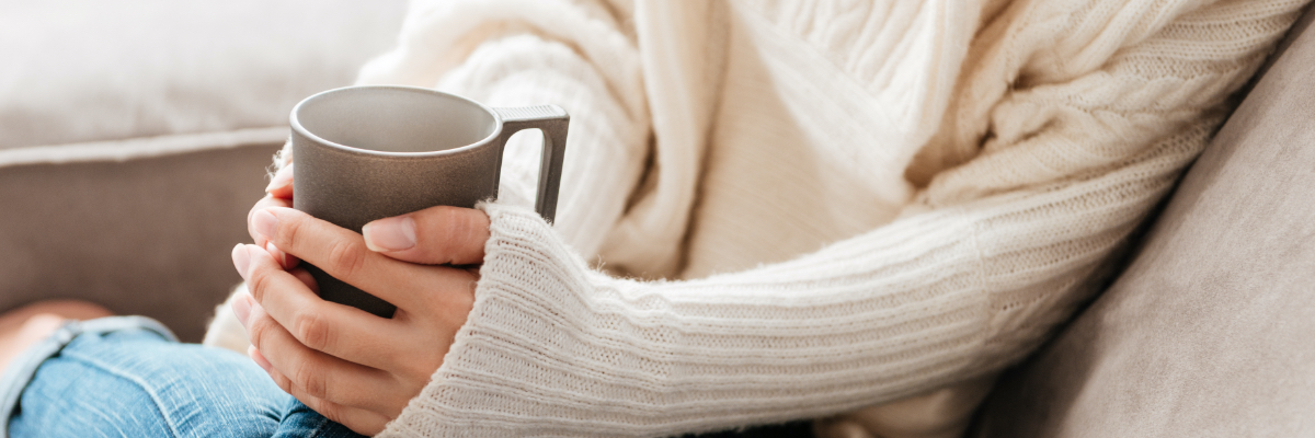 Woman in sweater holding coffee cup