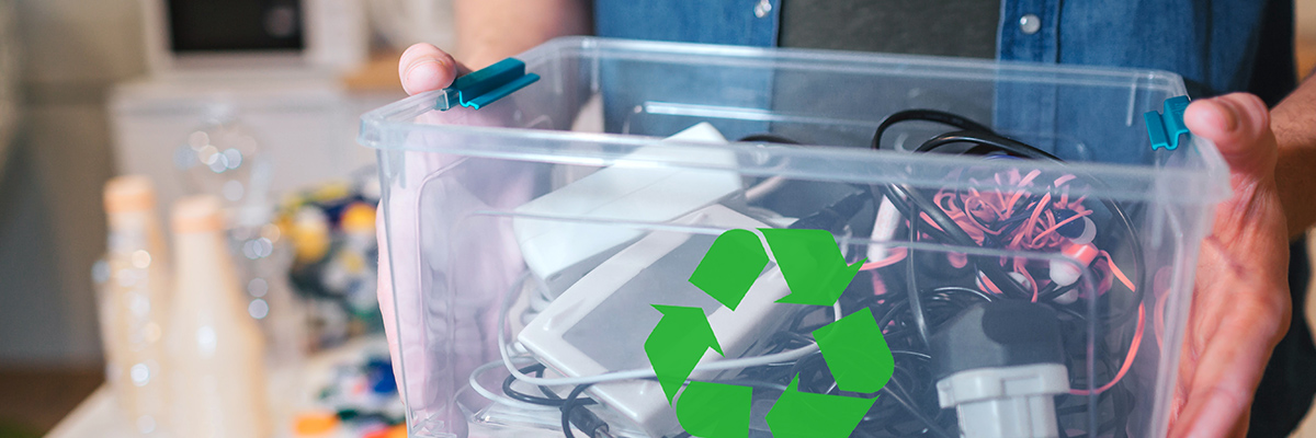 Man holding clear plastic bin of recycled electronic devices