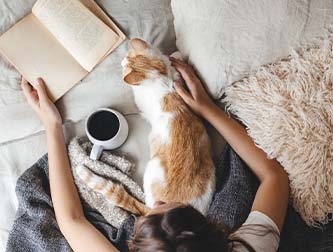 Cat on bed with coffee cup