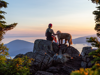 Woman hiker with dog overlooking lake