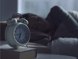 Woman sleeping next to alarm clock
