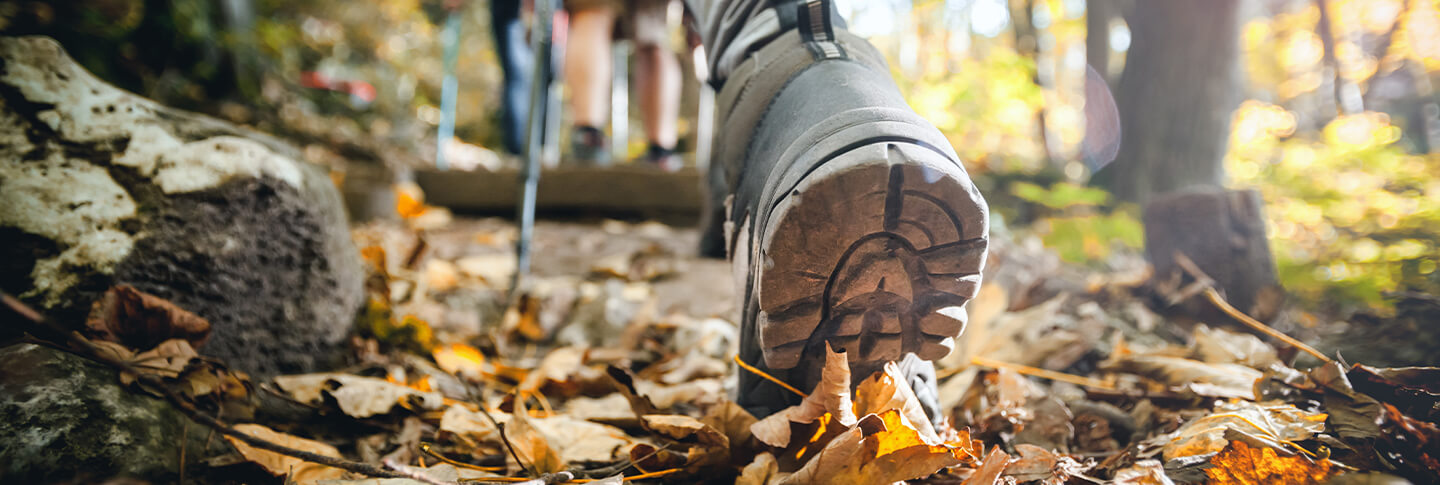 Hikers foot walking on fall trail