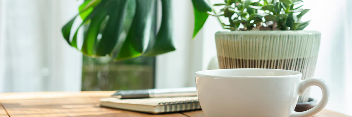 Coffee cup next to a notepad on side table, create a morning routine