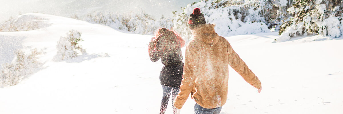 Couple playing in winter snow, date ideas in park city